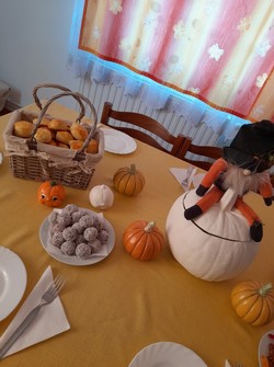 Szépen dekorált őszi hangulatú sütizéshez megterített asztal, kerámiatökökkel, manókával.